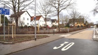 Zu sehen ist die Moselstraße mit der neu gestalteten verkehrsberuhigten Zone, man sieht die "30"er Markierung auf dem Boden, sowie ein Spielstraßenschild am linken Bildrand